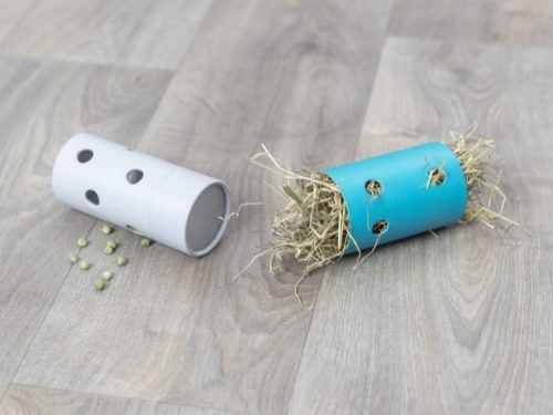 Håndlavede aktivitetsrør til gnavere i farverne hvid og blå, fyldt med hø og små huller til leg og udforskning. Perfekt til at stimulere nysgerrigheden hos mindre kæledyr.