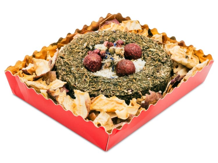 Naturlig snacks til gnavere, pakket i en rød æske med tørrede æblechips og urter. Ideel til hamstere, mus og andre små kæledyr.